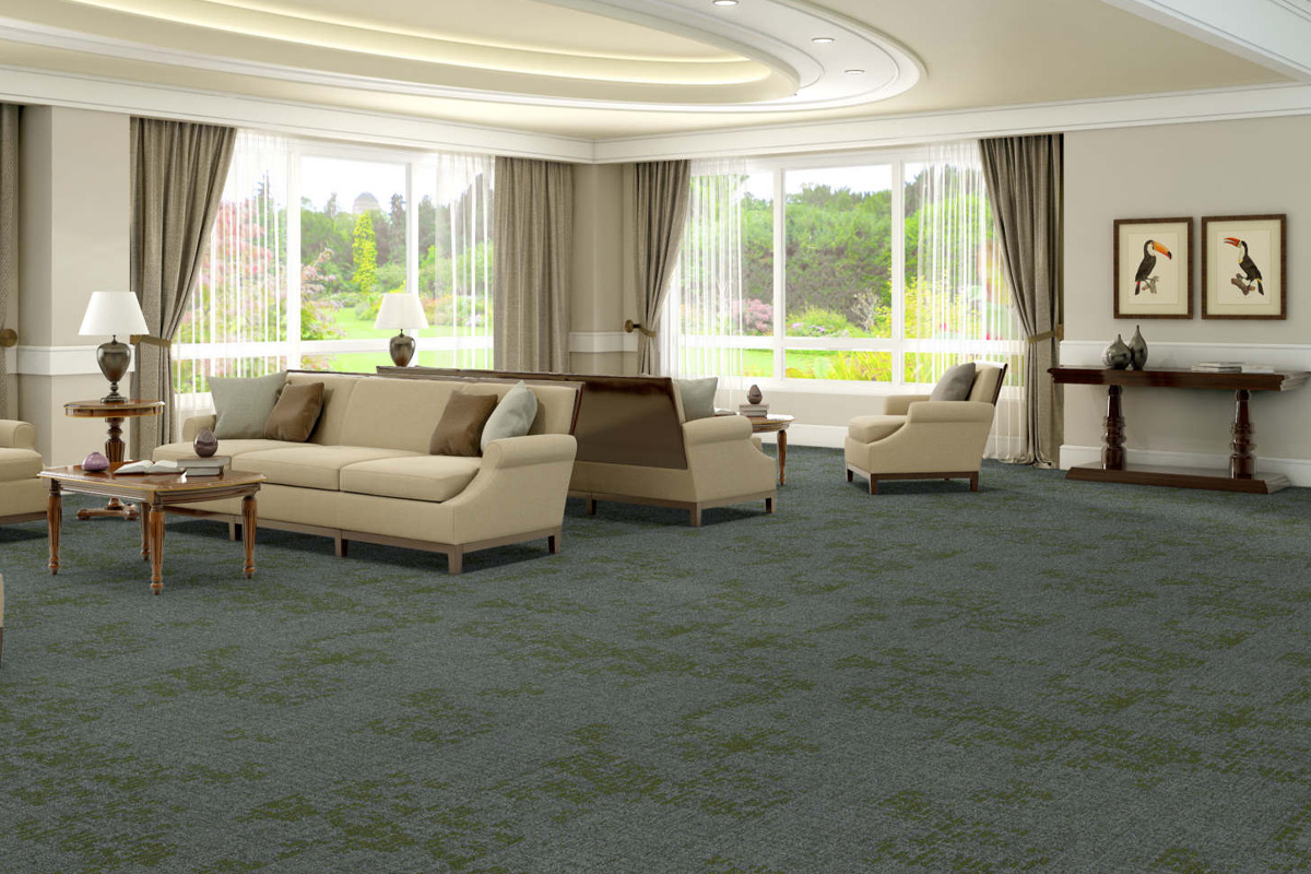 Green and gray commercial carpeting in a funeral home community room with beige couches.